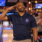 Illustrative mockup: Black veteran celebrating bowling in navy OVE polo